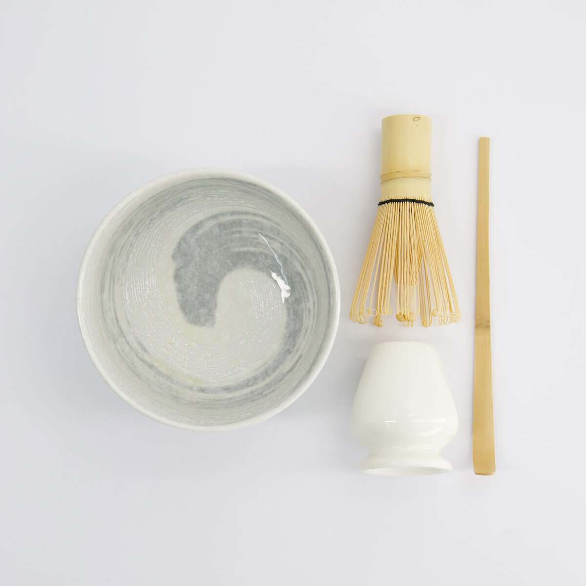Traditionele Japanse theeset met bamboe whisk, kom en lepel voor matcha thee, minimalistisch design op witte achtergrond.