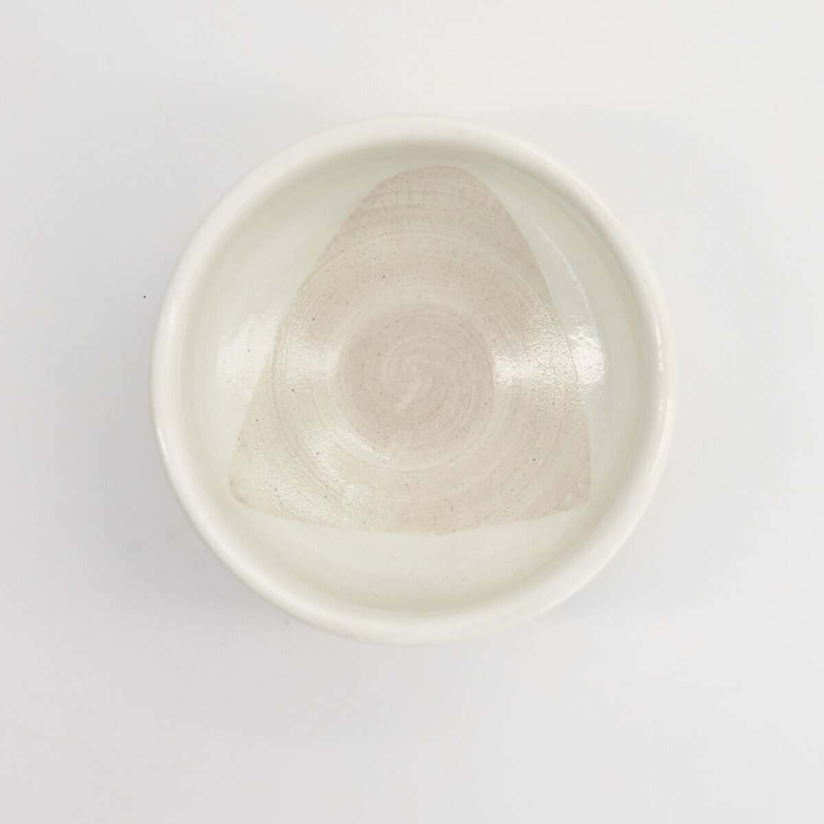 Witte keramische kom met een subtiele spiraalpatroon, geschikt voor koken en serveren, op een witte achtergrond.